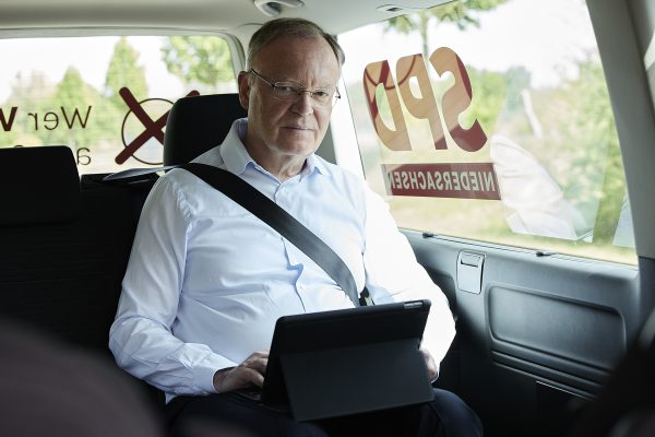 Stephan Weil im Auto vor seinem Tablet